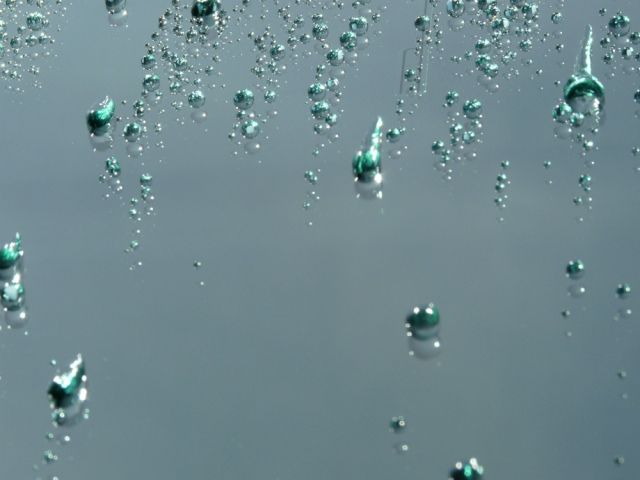 車のガラス面で撥水コーティング被膜に弾かれ、非常に接触角の高い状態で美しく撥水されている水滴のアップ画像